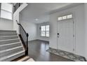 Open foyer with hardwood floors, stairway, and white walls creating a bright and welcoming space at 5530 Bower Pl, Cumming, GA 30028