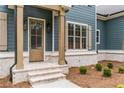 Close-up of the front entrance showcasing a wooden door, brick accents, and stylish shutters at 7636 Chestnut Hill Rd, Cumming, GA 30041