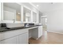 Elegant bathroom with double sinks, illuminated mirrors, and granite countertops offering a modern and sophisticated touch at 232 Orwell Dr, Social Circle, GA 30025