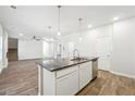 Contemporary kitchen island with dark granite countertops, stainless steel appliances, and bright pendant lighting, perfect for cooking at 232 Orwell Dr, Social Circle, GA 30025