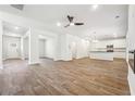Spacious living area with hardwood floors, ceiling fan, and open layout leading to a modern kitchen, ideal for entertaining at 232 Orwell Dr, Social Circle, GA 30025