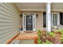 Charming brick porch with a dark-colored front door adorned with a wreath and decorative plants at 2920 Olde Towne Pkwy, Duluth, GA 30097