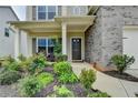 Inviting front porch showcases landscaping, a covered entrance, and stylish brick accents at 4650 Sandy Creek Dr, Cumming, GA 30028