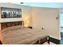 Bedroom with a wooden bed frame, neutral bedding, and modern city skyline art at 860 Peachtree Ne St # 2616, Atlanta, GA 30308