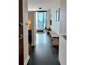 Inviting entryway with black floor, bench, and view into the well-lit living area with skyline views at 860 Peachtree Ne St # 2616, Atlanta, GA 30308