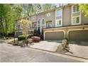 Attractive townhome exterior with a garage, landscaping, and close proximity to nature at 1209 Brookhaven Woods Ne Ct, Brookhaven, GA 30319