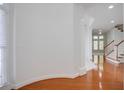 Bright hallway with hardwood floors, curved walls, and staircase in a well-lit home at 12554 Huntington Trce, Alpharetta, GA 30005