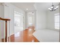 Open-concept living room featuring hardwood floors, staircase, and wainscoting at 12554 Huntington Trce, Alpharetta, GA 30005