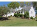 Beautiful two-story home featuring a cozy front porch, white siding and a green lawn with shrubs at 561 Valleyside Dr, Dallas, GA 30157