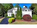 Stately white home with lush landscaping showcases a picturesque front facade on a sunny day at 7080 Greatwood Trl, Alpharetta, GA 30005
