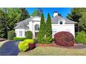 Well-maintained white home with manicured greenery and a vibrant garden at 7080 Greatwood Trl, Alpharetta, GA 30005