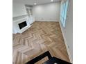 Bright living room with sleek herringbone floors, a cozy fireplace, and built-in shelving at 102 Adrian Nw Pl, Atlanta, GA 30327