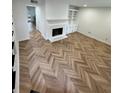 Bright living room with sleek herringbone floors, a cozy fireplace, and built-in shelving at 102 Adrian Nw Pl, Atlanta, GA 30327
