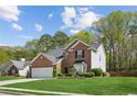 A beautiful two-story brick home with a well-kept lawn and mature landscaping at 2523 Bancroft Way, Buford, GA 30519