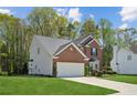A well maintained two-story brick home with attached garage on a lush green lawn at 2523 Bancroft Way, Buford, GA 30519