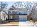 Beautiful two-story home with brick and gray siding, a two-car garage, and a well-kept lawn, perfect for Gathering living at 333 Gardens Of Harmony Dr, Canton, GA 30115