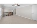 Bright and open loft area with neutral carpet, elegant railings, and ample space for a home office or play area at 333 Gardens Of Harmony Dr, Canton, GA 30115