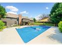 Backyard swimming pool with lounge chairs and shade, perfect for relaxing and entertaining at 3919 Evans Rd, Cumming, GA 30040