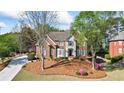 Charming two-story home with brick and siding exterior, mature trees, and well-maintained front yard at 6690 Stillmeadow Dr, Cumming, GA 30040
