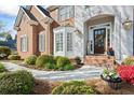 Inviting front entrance with beautiful landscaping, brick walkway, and a charming front door at 6690 Stillmeadow Dr, Cumming, GA 30040