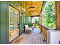 Inviting covered porch with stylish seating, a 'Hello' welcome mat, and elegant lighting fixture at 3244 Mount Olive Rd, Atlanta, GA 30344
