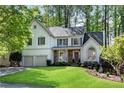 Charming two-story home with a well-manicured lawn, a gray roof, a two-car garage, and attractive landscaping at 4414 Aldenham N Way, Suwanee, GA 30024
