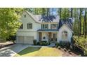 Two-story home has an attached two-car garage, stone veneer, and attractive landscaping at 4414 Aldenham N Way, Suwanee, GA 30024