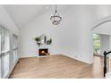 A bright living room with a modern chandelier, fireplace, and light wood flooring at 4414 Aldenham Nw Way, Suwanee, GA 30024