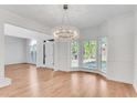 Bright dining room with elegant chandelier, bay window and wood floors at 4414 Aldenham Way, Suwanee, GA 30024