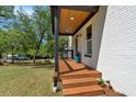 Charming covered front porch featuring wood flooring, steps, and a white brick foundation at 917 Derrydown Way, Decatur, GA 30030