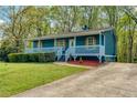 Beautiful one-story home featuring a delightful front porch, complemented by a well-manicured lawn and mature trees at 166 Rustin Dr, Dallas, GA 30157