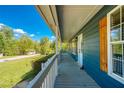 View from porch showing home's exterior details, including wooden shutters, light fixtures, and a scenic neighborhood view at 166 Rustin Dr, Dallas, GA 30157