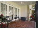 Tiled balcony with seating, ceiling fan, and garden bed full of bright flowers visible through the white doors at 311 Peachtree Hills Ne Ave # 17C, Atlanta, GA 30305