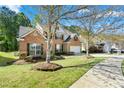 Lovely two-story brick home with mature trees and a well-kept lawn at 3889 Elm Trace Dr, Loganville, GA 30052