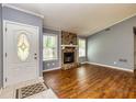 Inviting living room featuring hardwood floors, a stone fireplace, and bright natural light at 108 Dove, Peachtree City, GA 30269