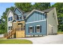 Side view of a two-story home showcasing blue and gray exterior, a wooden deck, and a convenient attached garage at 492 Mary Hill Ln, Douglasville, GA 30134