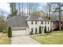 View of home exterior showing mature trees and manicured lawn at 300 Radner Run, Lawrenceville, GA 30043