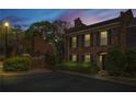 Charming two-story brick townhome featuring black shutters at twilight at 1 James River Ne Pl, Atlanta, GA 30342
