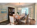 Elegant dining room with a wooden table set for six, a stylish chandelier, and dark hardwood floors at 1200 Izod Ct, Lawrenceville, GA 30044
