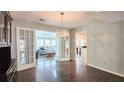 Open dining area with French doors leading to a sunroom, featuring a chandelier and hardwood floors at 1200 Izod Ct, Lawrenceville, GA 30044