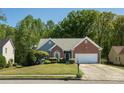 Inviting single-Gathering home with beautiful lawn, complemented by mature trees in a serene setting at 1570 Hill Crossing Ct, Grayson, GA 30017