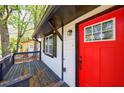 A close-up view of the home's exterior showcasing a bright red door and inviting front porch at 2077 Perkerson Rd, Atlanta, GA 30310