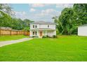 Charming two-story home features a well-manicured lawn, covered porch, and an orange front door at 90 Cerro St, Atlanta, GA 30314