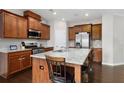Beautiful kitchen boasts granite countertops, stainless steel appliances, and dark hardwood flooring at 1427 Lanier Vista Dr, Sugar Hill, GA 30518