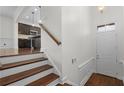 Open entryway featuring hardwood floors, stairs, and a view into the modern kitchen at 2171 W Village Se Ln, Smyrna, GA 30080