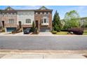 Street view of townhomes with garages, landscaped lawns, and a beautiful sky backdrop at 2171 W Village Se Ln, Smyrna, GA 30080