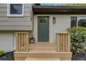 Inviting front door with brick accents, a decorative light fixture, and manicured landscaping at 2637 Crestdale Se Cir, Atlanta, GA 30316
