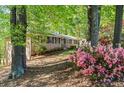 Brick home exterior with lush green landscaping and flowering shrubbery in a wooded setting at 1618 Cooper Lake Se Rd, Smyrna, GA 30082