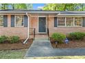 Brick front entrance with storm door, updated shutters, and security system sign at 1618 Cooper Lake Se Rd, Smyrna, GA 30082