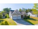 Beautiful exterior view of a tan home with an attached two-car garage and green front lawn at 1910 Charleston Oak Cir, Lawrenceville, GA 30043